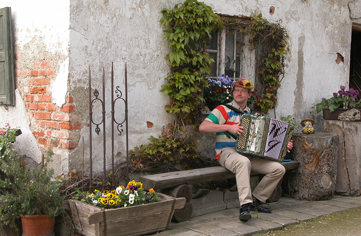 Foto van Werner op een bank die zijn accordion aan het bespelen is